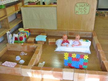 子どもたちが大型積木を使って作ったお家 ソファも作りブロックで組み立てた薄型テレビを見ています。